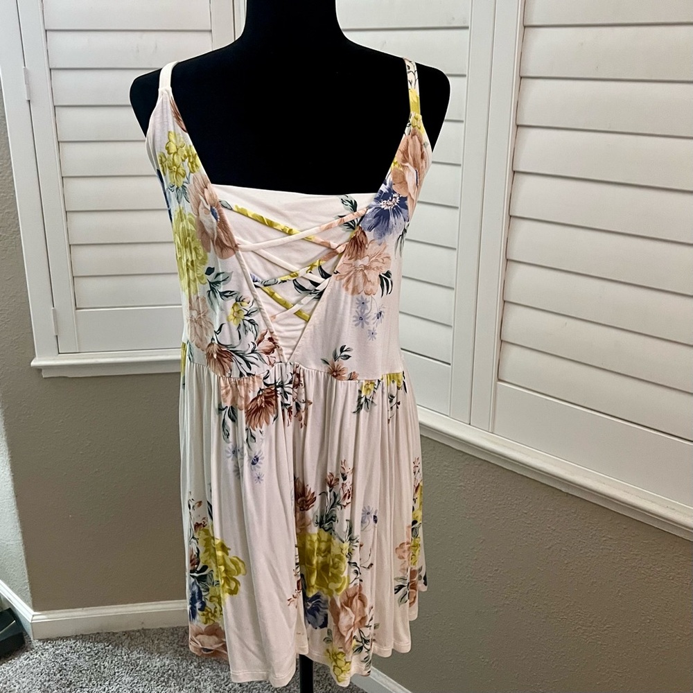 White and pink floral print tunic shirt with crisscross pattern in the front.